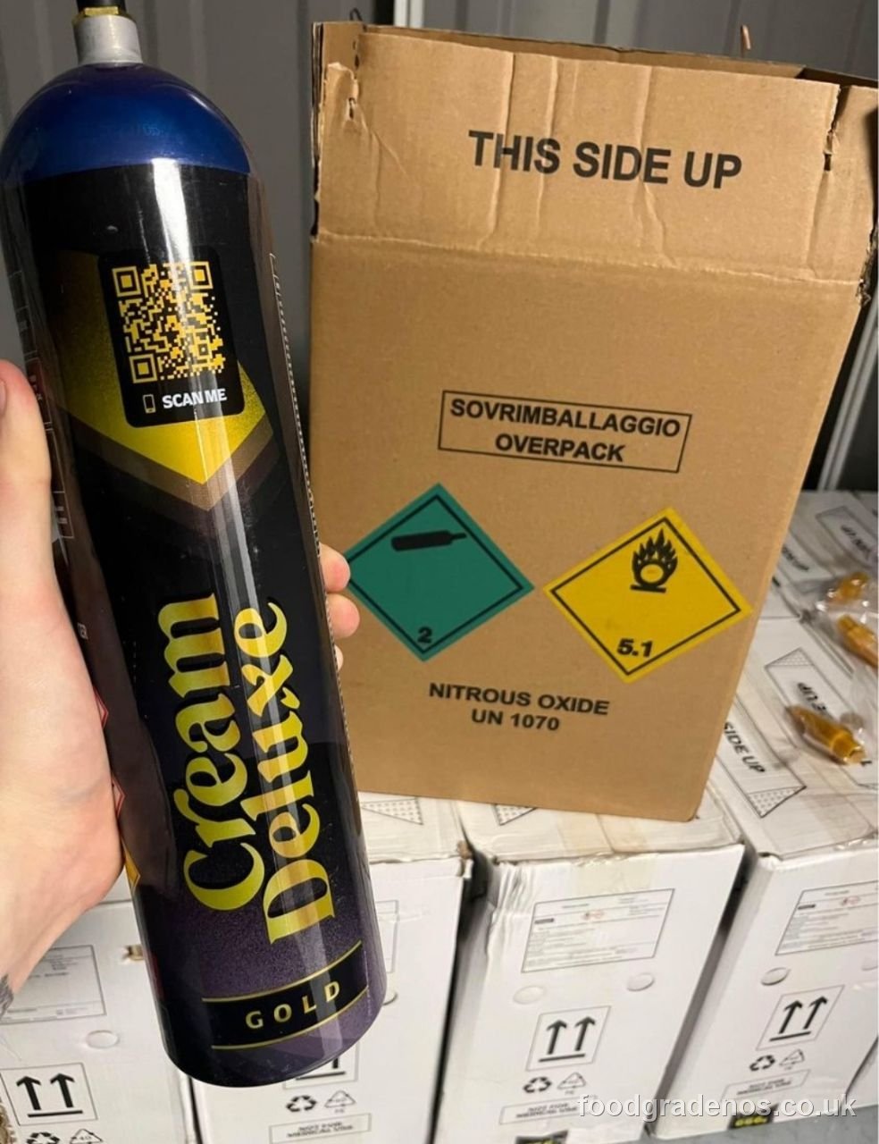 Hand holding a Cream Deluxe Gold cylinder with a scannable QR verification code